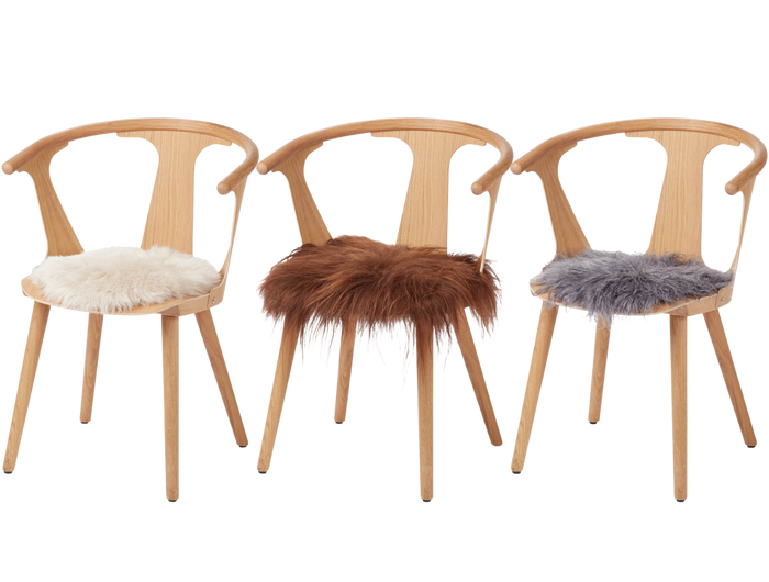 three sheepskin seat covers on chairs